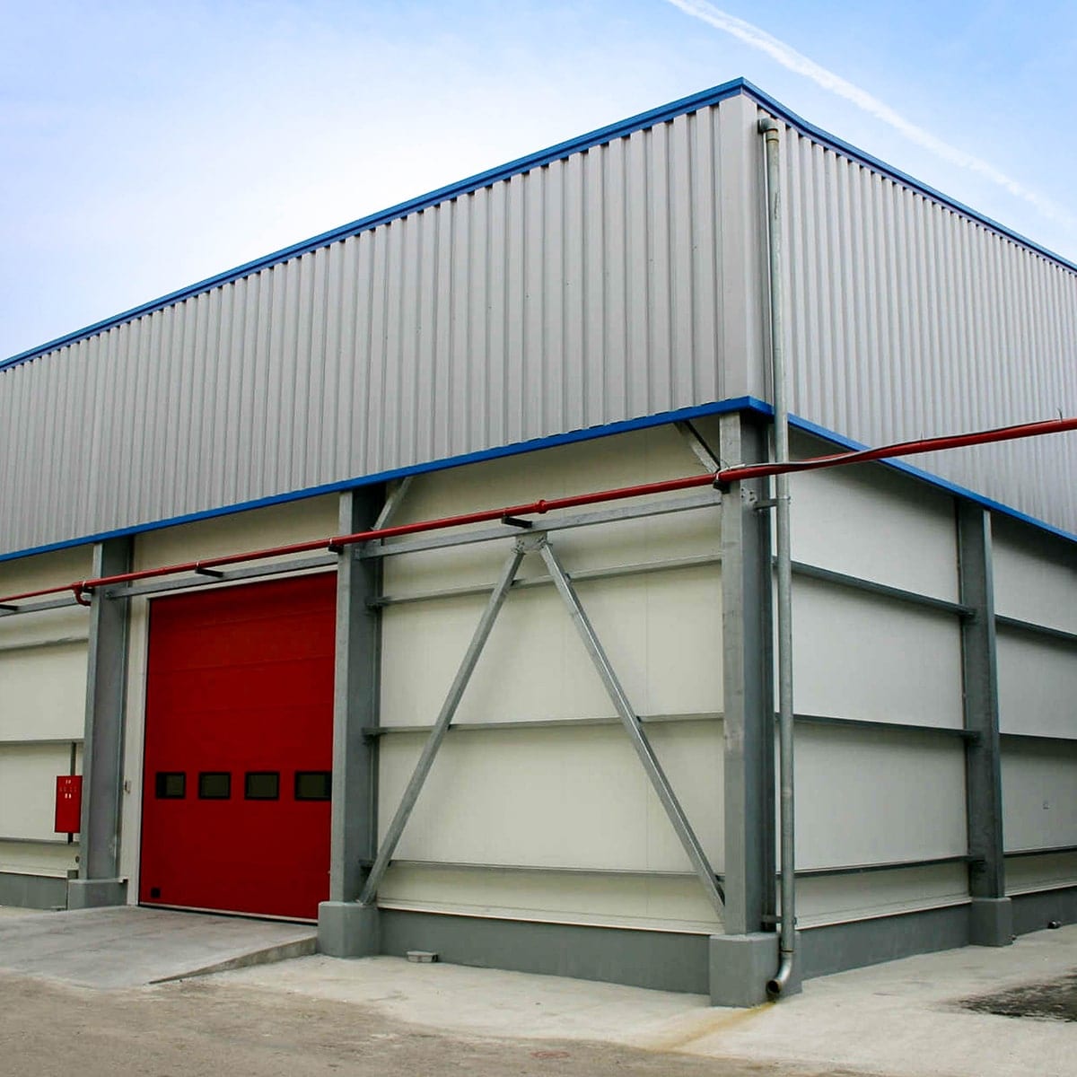 Ολοκληρωμένη μεταλλική αποθήκη της ΙΟΝ ΑΕ με κόκκινη βιομηχανική πόρτα στην Άρτα