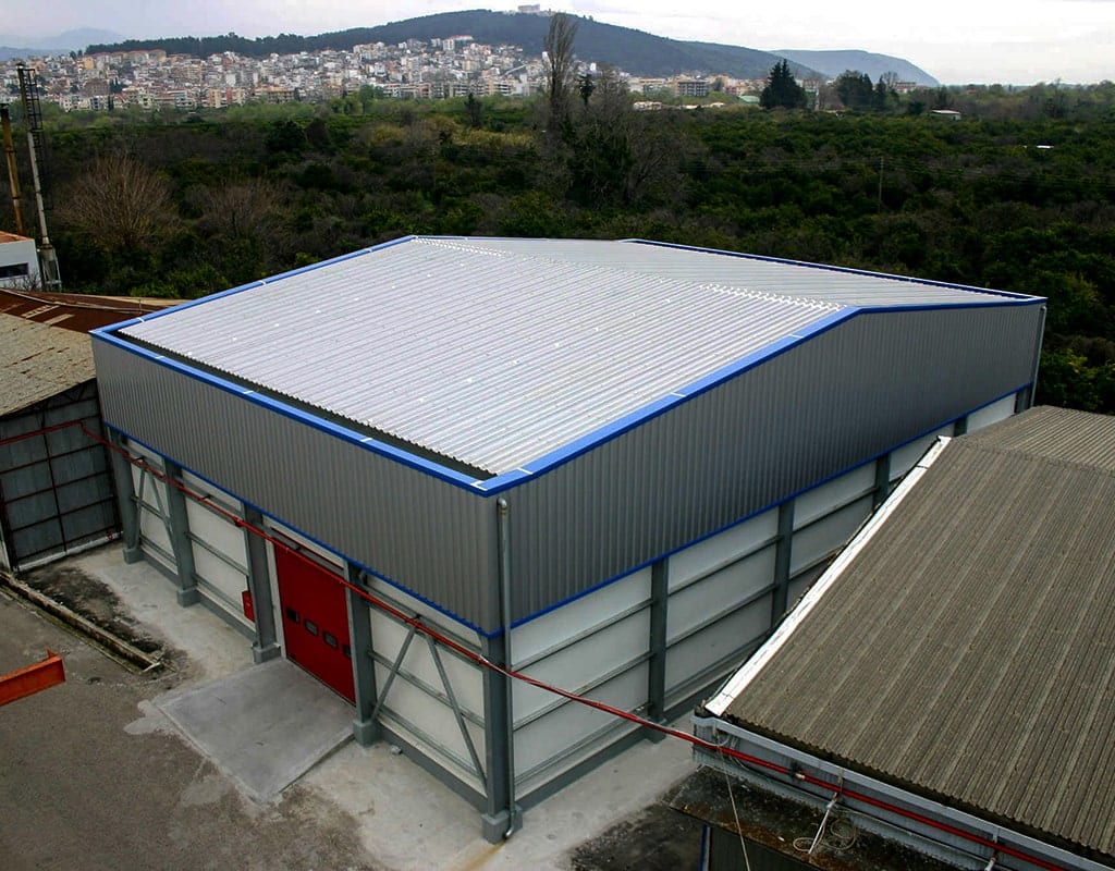 Αεροφωτογραφία της μεταλλικής αποθήκης της ΙΟΝ ΑΕ με την πόλη της Άρτας στο βάθος