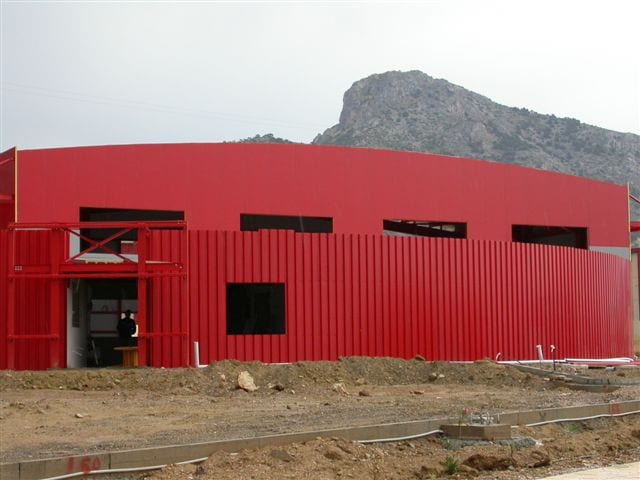 Καμπύλη πρόσοψη με κόκκινη επένδυση λαμαρίνας του ΙΚΤΕΟ στον Ασπρόπυργο