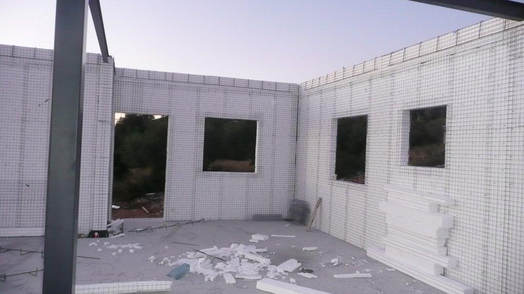 Εσωτερική όψη τοίχων από πάνελ τύπου 3Δ με ανοίγματα παραθύρων στις Lithos Villas