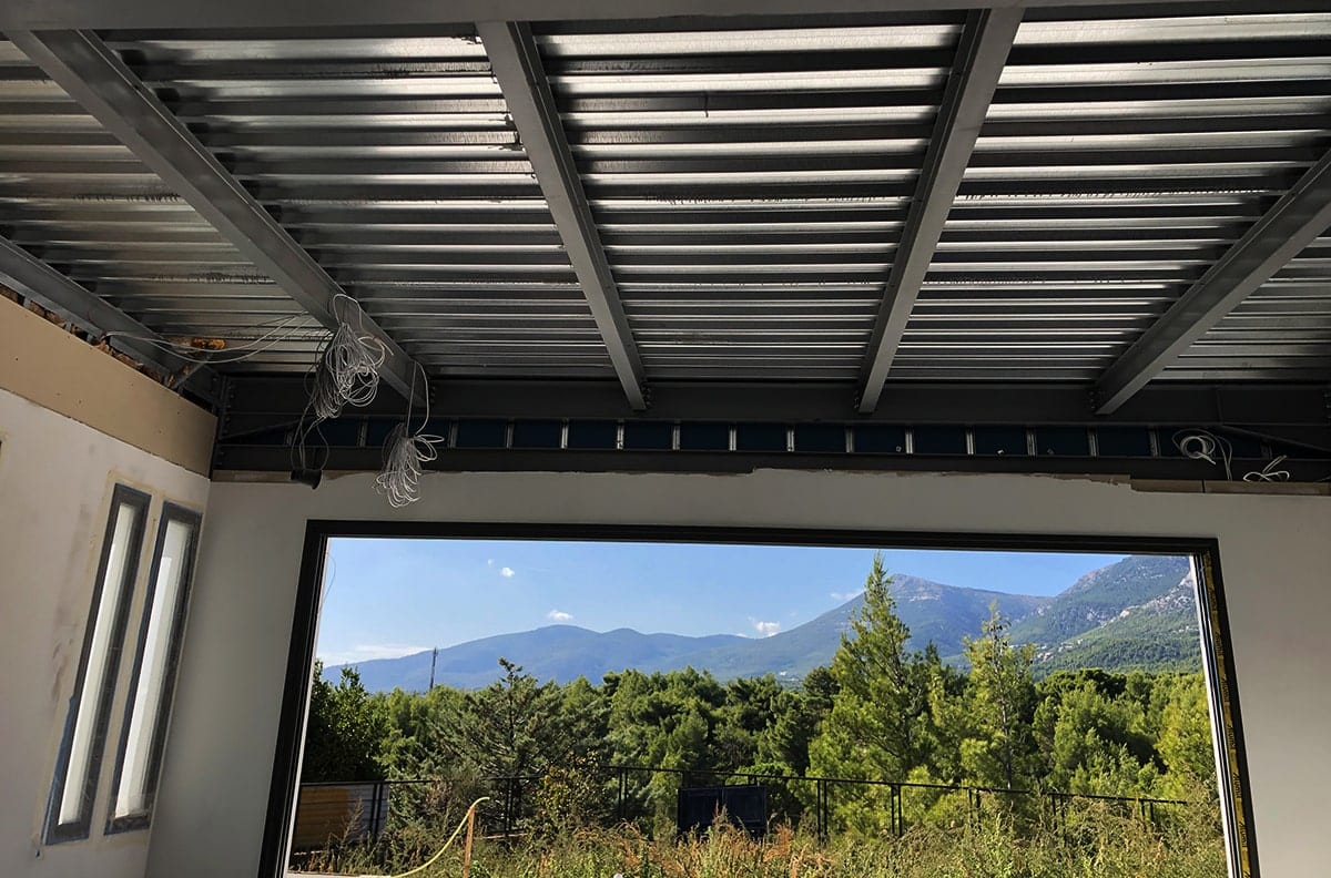 Πατάρωμα με μεταλλικές δοκούς και μεγάλο άνοιγμα με θέα στη μεζονέτα στη Βαρυμπόμπη