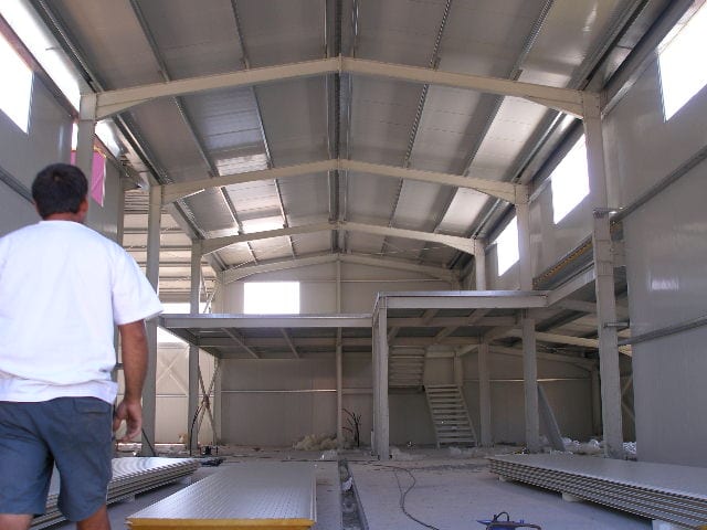 Εσωτερικό της ποτοποιίας στην Παραμυθιά με μεταλλικό πατάρι, σκάλα και πάνελ
