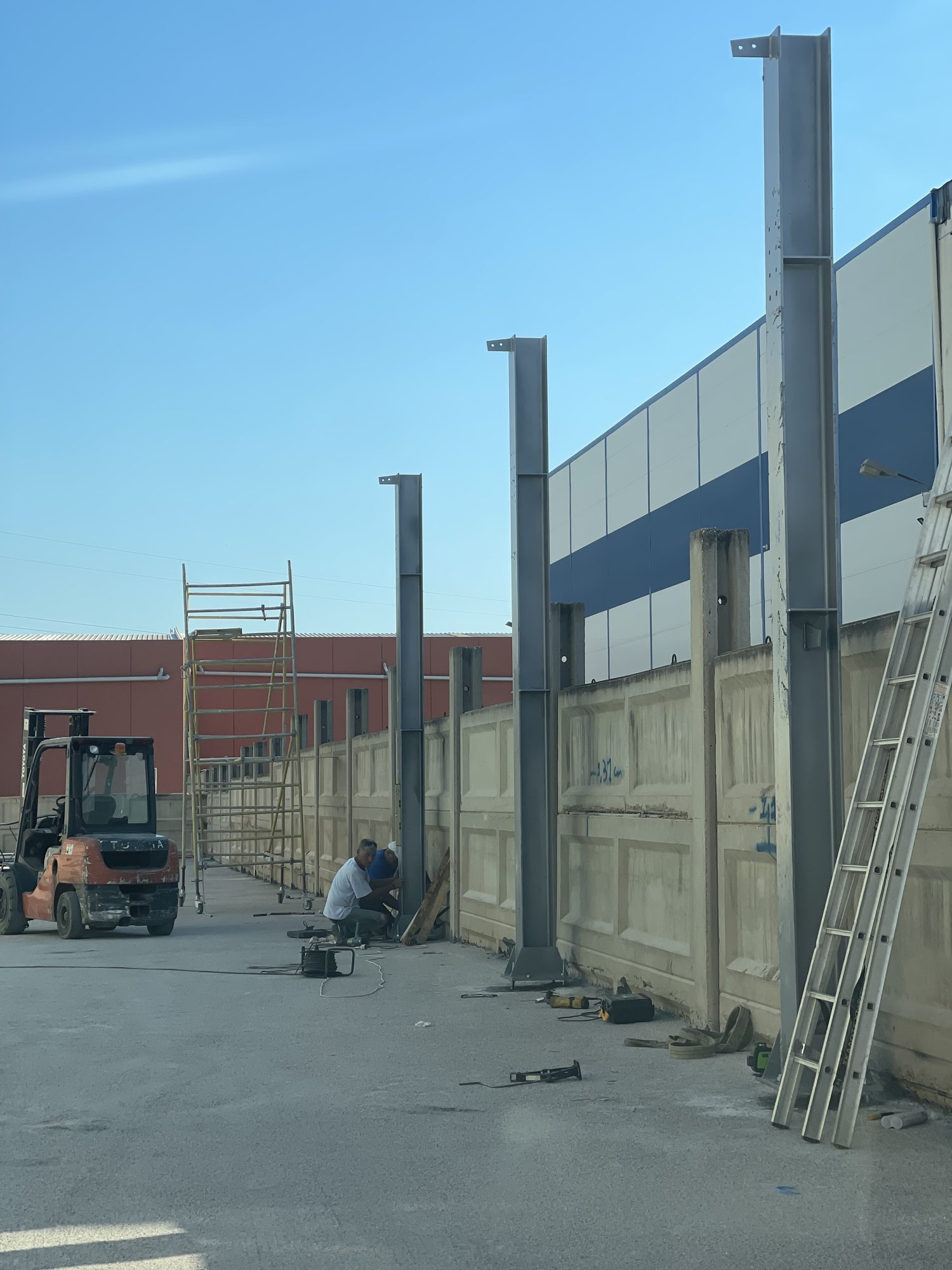 Χαλύβδινα υποστυλώματα HEA στημένα κατά μήκος του τοίχου του οικοπέδου, Ασπρόπυργος